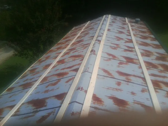 Rusted metal roof panels with new wood purlins before replacement — Storm Damage Roof Repair in Maury City by Roofing Brothers