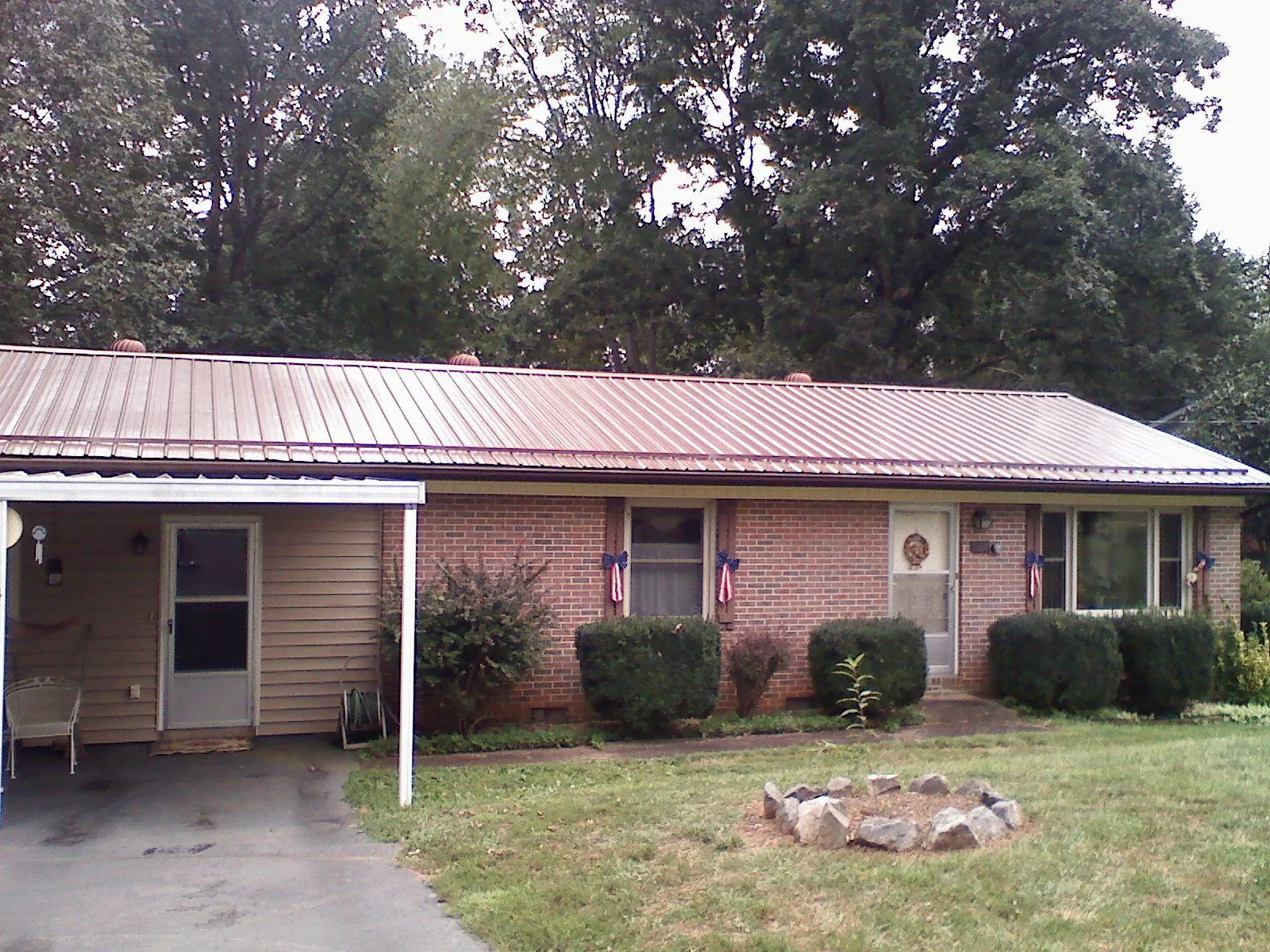 Bronze metal roof and carport on a brick ranch home — Roof Repair work by our crew in Maury City